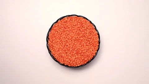 Heap of raw uncooked red lentils in bowl in rotation Stock Footage 128764203