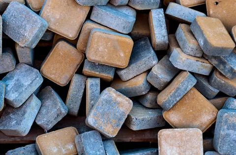 Heap of rectangular paving slabs with orange paint, building material. Stock Photos