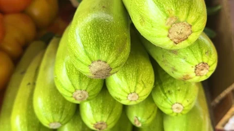 Heap of ripe courgettes on bazaar counter with fresh summer vegetables and Stock Footage 345730164