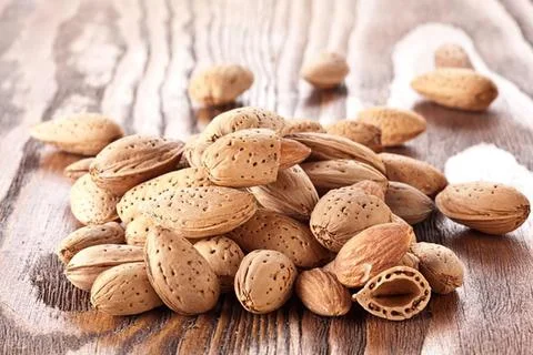 Heap of roasted peanuts on a rustic cloth surface Stock Photos