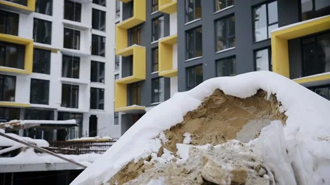 Heap of sand on the construction territory in winter time. Pile of sand covered Stockbeeldmateriaal 258679352