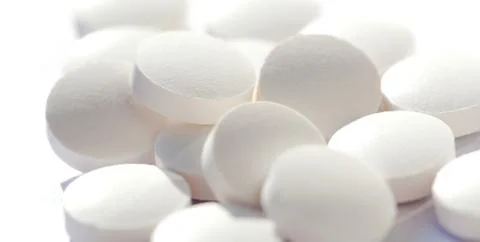 Heap of simple tiny round white pills loose, group of small tablets on white Stock Photos
