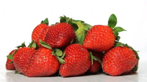 A heap of strawberries with leafs rotating against white background 4K. 動画素材 62274368