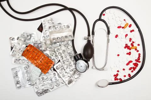 Heap of tablets, pills, empty blisters, tonometer, phonendoscope on white Stock Photos