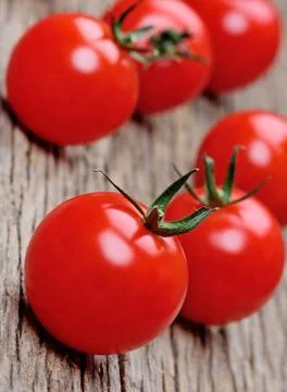 Heap of tomato cherry on rustic table Stock Photos