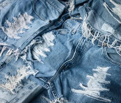 Heap of torn and frayed, threadbare jeans Stock Photos