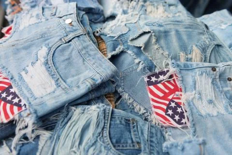 Heap of torn and frayed, threadbare jeans Stock Photos