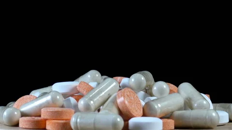 Heap of various pills on black Stock Footage 142960831