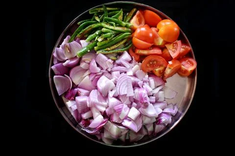 Heaps of different cut vegetables isolated on black background as package des Stock Photos