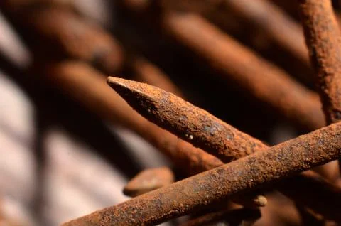 Heaps of used nails made of rusty iron material are brown mixed with black sp Stock Photos