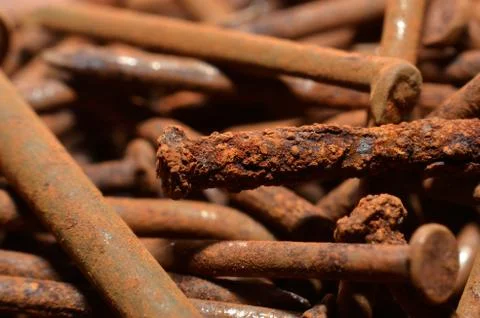 Heaps of used nails made of rusty iron material are brown mixed with black sp Stock Photos
