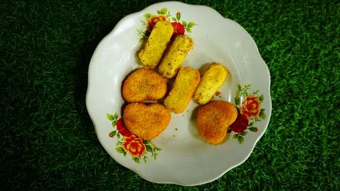 Hear shaped and Rectangular Breaded Snacks on Floral Plate Stock Photos