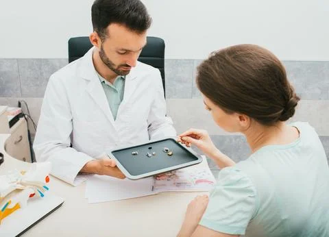 Hearing solution for adults. Audiologist selecting a hearing aid for a caucas Foto stock