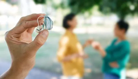 Hearing solutions. Last generation of hearing aid device in human hand with u Fotos Stock