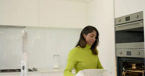 Hearing timer, diverse couple pulling pie from oven using thick cloth, smelling Stock Footage 317641968