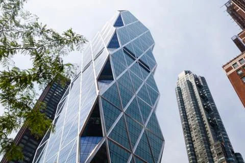The hearst tower in new york between other skyscrapers with blue sky Stock Photos