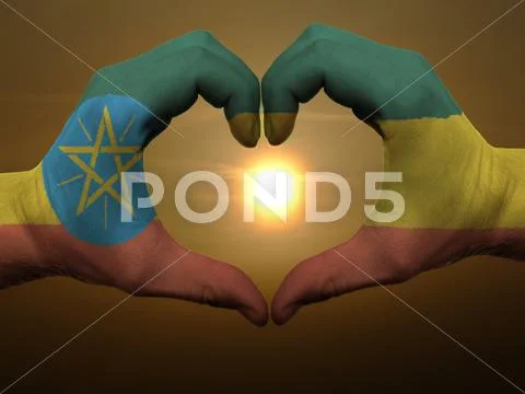 Heart and love gesture by hands colored in ethiopia flag during beautiful sun Stock Photos