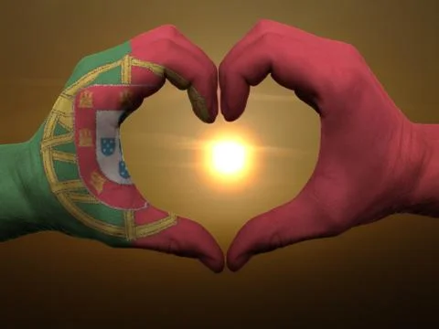 Heart and love gesture by hands colored in portugal flag during beautiful sun Stock Photos