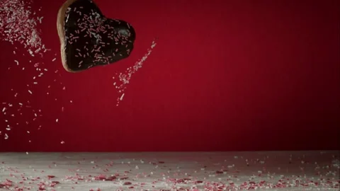 Heart chocolate donut falling on pink and white sprinkles Stock Footage 327632017