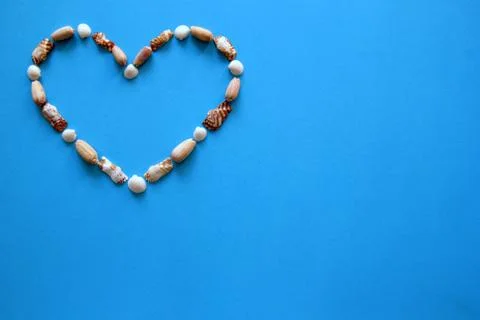 A heart from different seashells on the blue background for Valentine's Day. Foto stock