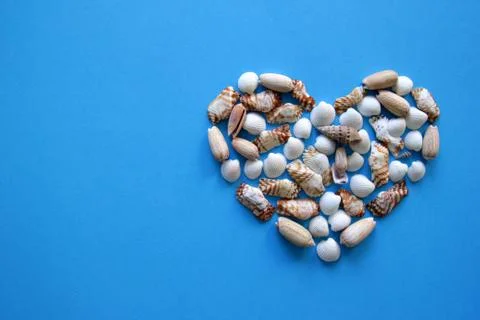 A heart from different seashells on the blue background for Valentine's Day. Foto stock
