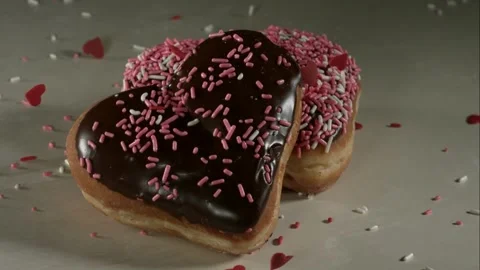 Heart donuts with sprinkles falling on them Stock Footage 326749940