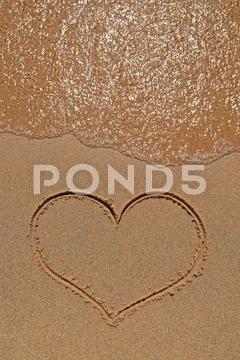 Heart drawing on sandy beach Stock Photos