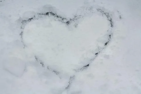 A heart drawn on a background covered with first snow Stock-Fotos