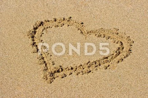 Heart drawn on beach sand Stock Photos