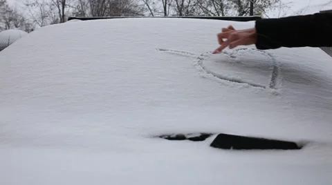 Heart drawn on a car window covered with snow Stock Footage 44496627