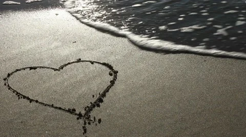 Heart drawn in the sand (with wave) Stock Footage 10708785