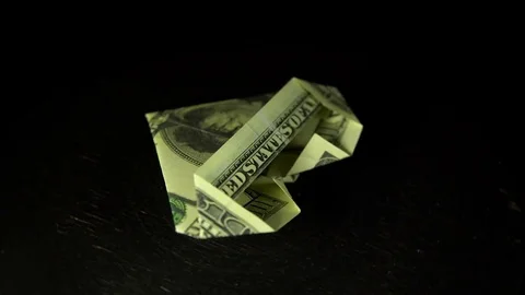 A heart folded from a dollar bill rotates against a black background. Stock Footage 83172281