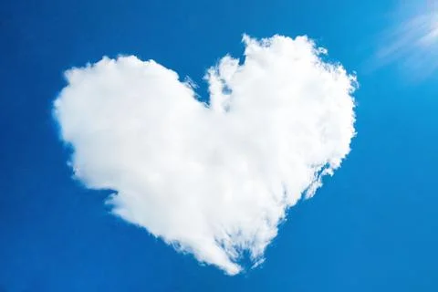 Heart in the form of a cloud against the blue sky with the rays of the sun, out Stock Photos