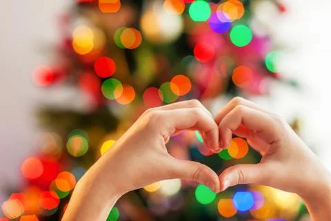 Heart from the hands in front of  christmas tree Stock Photos