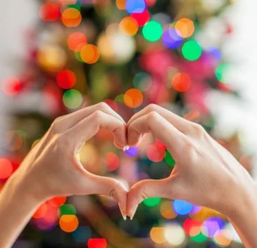 Heart from the hands in front of  christmas tree Stock Photos