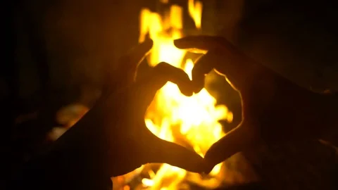Heart Hands show in front of fire, fire looks into the camera through the form Stock Footage 73828964