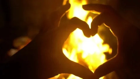 Heart Hands show in front of fire, fire looks into the camera through the form Stock-Footage 73828991