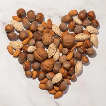 Heart made of nuts on a gray background Stock Photos