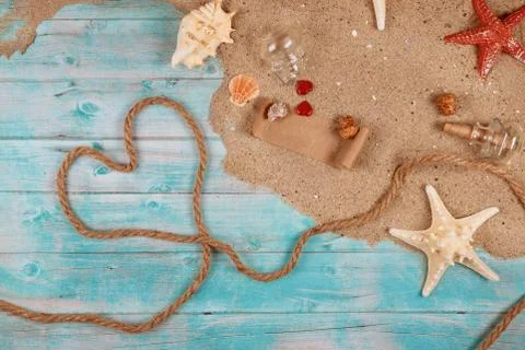 Heart made from rope on seashore with shells, sand and starfish. Papyrus from Stockfoto's