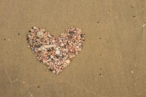 Heart made of sea shells lying on a beach sand 스톡 사진
