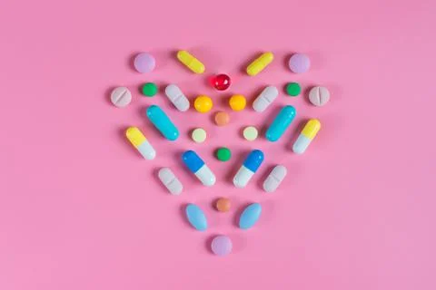 The heart is made up of tablets on a pink background Stock Photos