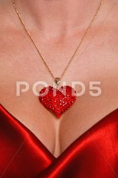 Heart necklace and red satin dress Stock Photos
