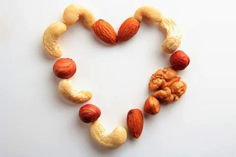 Heart of nuts on a white background. Assorted peeled nuts for a healthy diet. Stock Photos