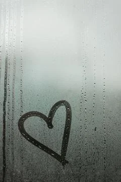 Heart painted on a misted window Stock Photos