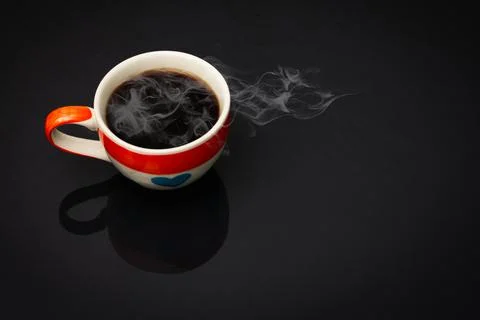 Heart pattern coffee cup In the cup there is black coffee and smoke on black Stock Photos