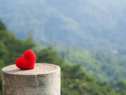 Heart put on stone The background is a forest and mountains. copy space for t Stock Photos