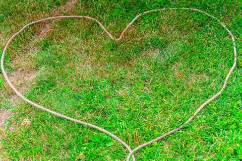 Heart with a rope laid on the meadow Stock Photos