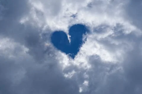 Heart shape on blue sky with clouds Stock Photos