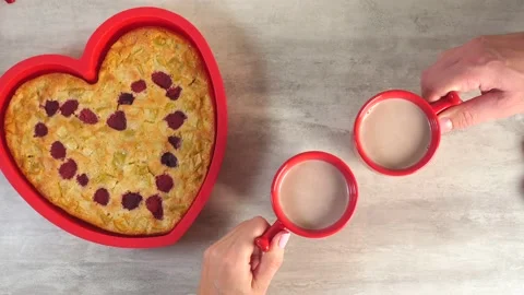 Heart shape cake silicon mould with hot drink cups in couple hands Stock Footage 221148567