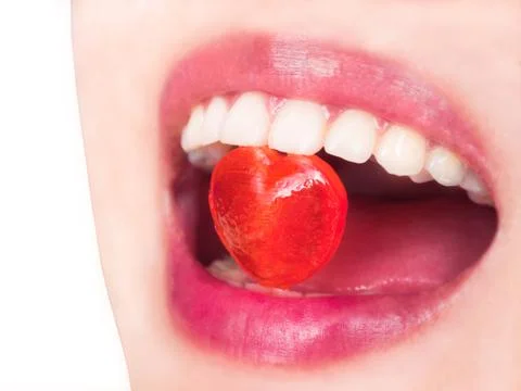 Heart shape candy in red lip Stock Photos